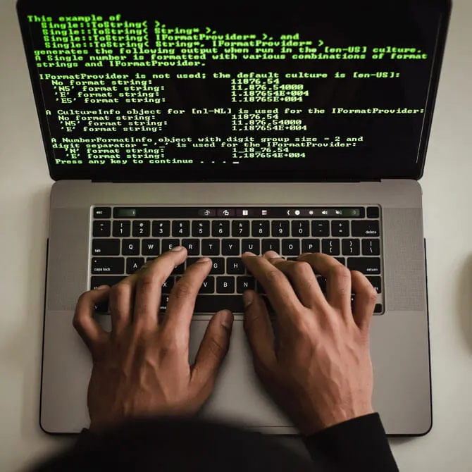 Two hands typing on keyboard.